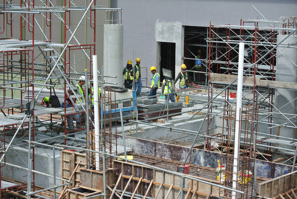 SERDANG, MALAYSIA -JUNE 13, 2016: Construction site in progress at Serdang, Malaysia during the daytime. Workers busy with their task installing formwork and reinforcement bar.