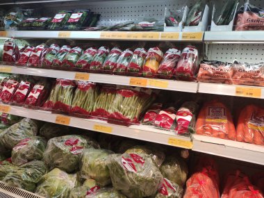 KUALA LUMPUR, MALAYSIA - 16 Temmuz 2020: Sebzeler plastik bir kapta ve plastik ambalajda paketlenmiştir. Süpermarketteki soğutucu rafında sergilendi. 