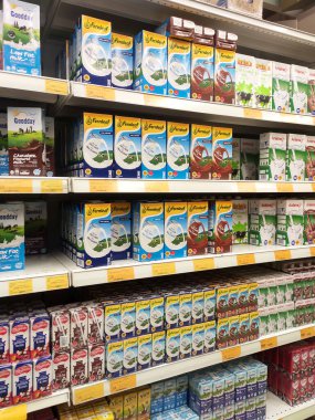 SEREMBAN, MALAYSIA - 5 Temmuz 2019: İşlenmiş ve taze süt kağıt kutuda paketlenmiş ve süpermarketlerin içindeki raflarda sergilenmektedir. Markaya göre sıralanır ve müşterinin seçmesi kolay olur.. 