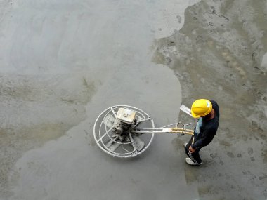 KUALA LUMPUR, MALAYSIA - 16 Temmuz 2017: Şantiyedeki inşaat işçilerinin elektrik şamandırası çalışmaları. Elektrik şamandırası ıslak betonu düzleştirmek için kullanılmış.. 