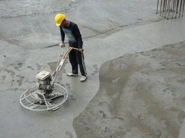 KUALA LUMPUR, MALAYSIA - 16 Temmuz 2017: Şantiyedeki inşaat işçilerinin elektrik şamandırası çalışmaları. Elektrik şamandırası ıslak betonu düzleştirmek için kullanılmış.. 