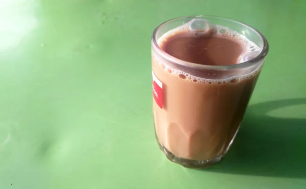 マレーシアのシグネチャードリンク Teh Tarik お茶をクリーム色の白いクリームと混ぜ合わせます クリームはパーム油ベースで作られています — ストック写真