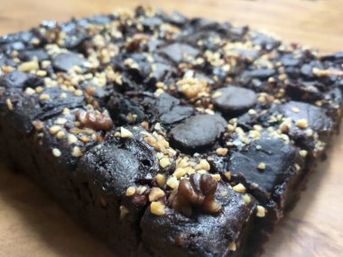 Çikolatalı pastaya odaklanmış. Dikdörtgen şeklinde. Ezilmiş bademler üzerine serpilmiş. Daha kolay yemek yiyebilmek için küçük küplere bölünmüş..