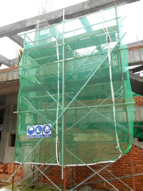 KUALA LUMPUR, MALAYSIA - 4 Temmuz 2017: İnşaat sırasında küçük inşaat atıklarının düşmesini önlemek ve yakalamak için dış duvar inşaatına kurulmuş güvenlik ağı.