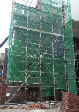 KUALA LUMPUR, MALAYSIA - 4 Temmuz 2017: İnşaat sırasında küçük inşaat atıklarının düşmesini önlemek ve yakalamak için dış duvar inşaatına kurulmuş güvenlik ağı.