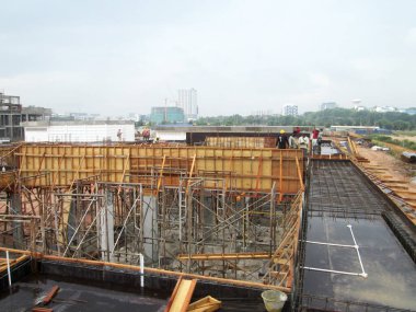 KUALA LUMPUR, MALAYSIA -ECTOBER 04, 2017: İnşaat alanında işçiler tarafından beton yapı kalıbı olarak üretilen kontrplak ve kerestelerden yapılan ahşap işleri.  