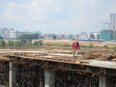 KUALA LUMPUR, MALAYSIA -ECTOBER 04, 2017: İnşaat alanında işçiler tarafından beton yapı kalıbı olarak üretilen kontrplak ve kerestelerden yapılan ahşap işleri.  