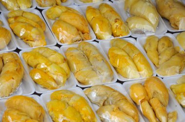Durian meyveleri plastik yiyeceklerle açıldı ve paketlendi. Satmak için satırlarda gösterilir.