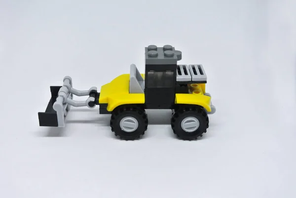Hračkový Buldozer Žlutých Černých Plastových Cihel Kolečky Izolovanými Bílém Pozadí — Stock fotografie