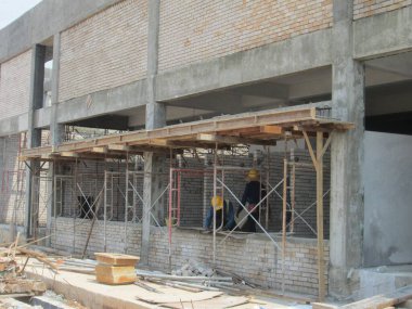 KUALA LUMPUR, MALAYSIA - 25 Mart 2017: Tuğlacı kalsiyum silikat tuğla blokları ve inşaat alanında duvar oluşturmak için beton harç kullanarak bir araya getirildi. 