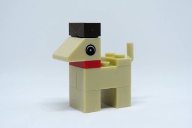 Plastik oyuncak bloklardan yapılmış ve beyaz arka planda izole edilmiş bir köpeğin şekline odaklanmış