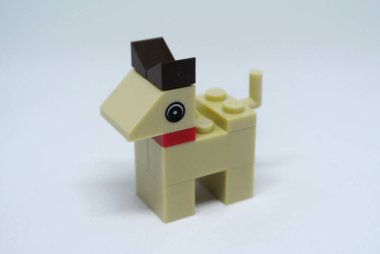 Plastik oyuncak bloklardan yapılmış ve beyaz arka planda izole edilmiş bir köpeğin şekline odaklanmış