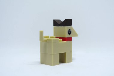 Plastik oyuncak bloklardan yapılmış ve beyaz arka planda izole edilmiş bir köpeğin şekline odaklanmış