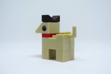 Plastik oyuncak bloklardan yapılmış ve beyaz arka planda izole edilmiş bir köpeğin şekline odaklanmış