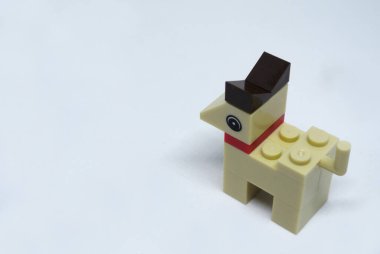 Plastik oyuncak bloklardan yapılmış ve beyaz arka planda izole edilmiş bir köpeğin şekline odaklanmış