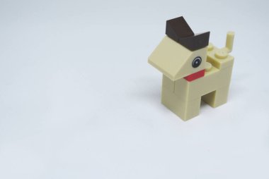 Plastik oyuncak bloklardan yapılmış ve beyaz arka planda izole edilmiş bir köpeğin şekline odaklanmış