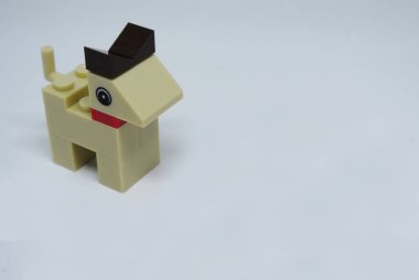 Plastik oyuncak bloklardan yapılmış ve beyaz arka planda izole edilmiş bir köpeğin şekline odaklanmış