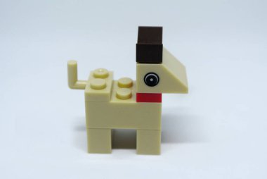 Plastik oyuncak bloklardan yapılmış ve beyaz arka planda izole edilmiş bir köpeğin şekline odaklanmış