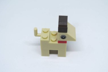 Plastik oyuncak bloklardan yapılmış ve beyaz arka planda izole edilmiş bir köpeğin şekline odaklanmış