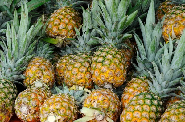 SERDANG, MALAYSIA - 30 Eylül 2017: Piyasadaki çiftçi masasında hasat edilen ve satılmak üzere sergilenen ananas meyveleri. 