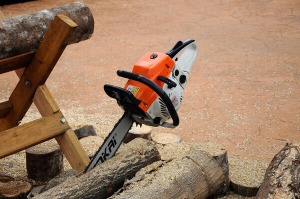SERDANG, MALAYSIA-SEPTEMBER 30, 2017: Mechanical powered chain saw used to cut timber. Управление вручную мужчинами. 