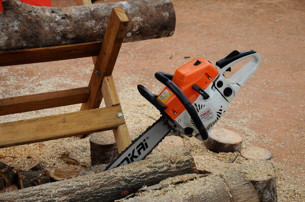 SERDANG, MALAYSIA-SEPTEMBER 30, 2017: Mechanical powered chain saw used to cut timber. Управление вручную мужчинами. 