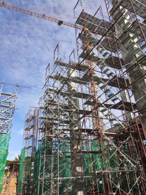 SELANGOR, MALAYSIA -4 AĞUSTOS 2020: Yüksek beton sütunların yapımında geçici merdiven ve iskeleler kullanılır. İskele, güvenlik amaçlı güvenlik ağlarıyla sarılı..
