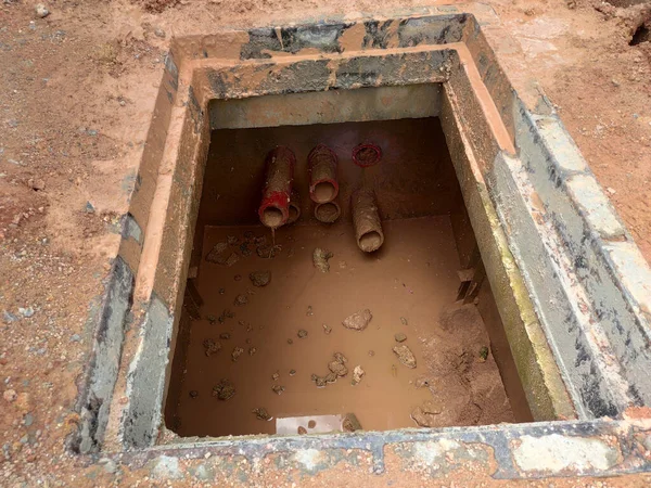 SEREMBAN, MALAYSIA -AUGUST 6, 2020: Utility services manhole and underground pipes under construction at the construction site. In-situ construction by workers based on infrastructure engineer design. — Stock Image Seremban Malaysia August 2020 Utility Services Manhole Underground Pipes Construction Royalty Free Stock Photos