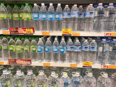 KUALA LUMPUR, MALAYSIA -15 Nisan 2020: İçme suyu paketlenir ve plastik şişelerde çeşitli markalarla etiketlenir. Süpermarketin içindeki bir rafta gösteriliyor.