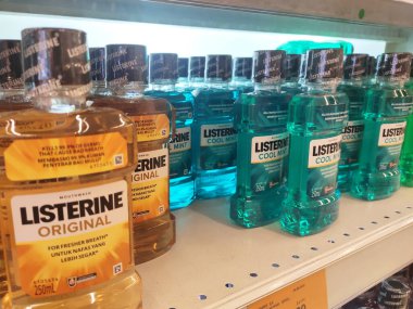SEREMBAN, MALAYSIA -MARCH 9, 2020: Selective focused of liquid mouthwash product displayed for sale on the rack inside the supermarket. Sorted by the brand for easy for the customer to choose.  clipart