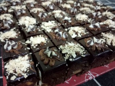 Çikolatalı ve peynirli pastaya odaklanmış. Dikdörtgen şeklinde. Daha kolay yemek yiyebilmek için küçük küplere bölünmüş..