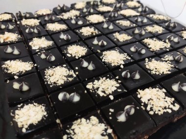 Çikolatalı ve peynirli pastaya odaklanmış. Dikdörtgen şeklinde. Daha kolay yemek yiyebilmek için küçük küplere bölünmüş..