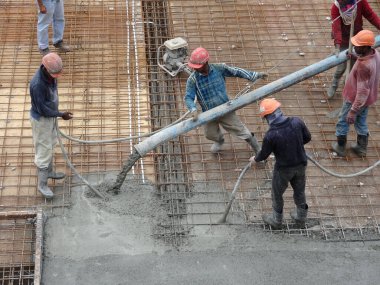KUALA LUMPUR, MALAYSIA - 16 Haziran 2017: İnşaat işçileri inşaat sahasındaki beton pompalama makinesinin beton örümcek hortumunu kullanarak beton beton döşeyen inşaat işçileri.  
