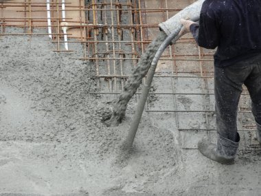 KUALA LUMPUR, MALAYSIA - 16 Haziran 2017: İnşaat işçileri inşaat sahasındaki beton pompalama makinesinin beton örümcek hortumunu kullanarak beton beton döşeyen inşaat işçileri.  