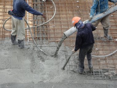 KUALA LUMPUR, MALAYSIA - 16 Haziran 2017: İnşaat işçileri inşaat sahasındaki beton pompalama makinesinin beton örümcek hortumunu kullanarak beton beton döşeyen inşaat işçileri.  