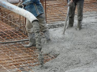 KUALA LUMPUR, MALAYSIA - 16 Haziran 2017: İnşaat işçileri inşaat sahasındaki beton pompalama makinesinin beton örümcek hortumunu kullanarak beton beton döşeyen inşaat işçileri.  