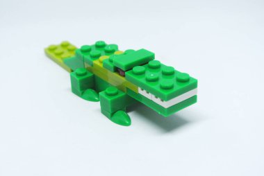 Yeşil timsah şekli renkli plastik oyuncak tuğlalardan yapılır..