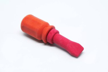 Seçici odaklanma, beyaz arka planda izole edilmiş kırmızı ve turuncu kauçuktan yapılmış oyuncak tornavida görüntüsü.