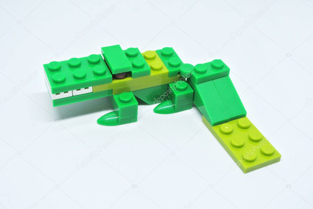 The shape of a green crocodile is made from colourful plastic toy bricks.