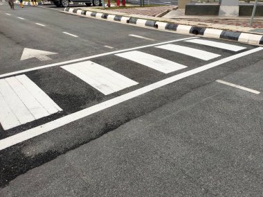 Zebra yayalar için yoldan geçiyor. Termoplastik malzemeden yapılmış ve ışık yansıtan parçacıklara sahip. Yayalara güvenlik avantajı sağlıyor.