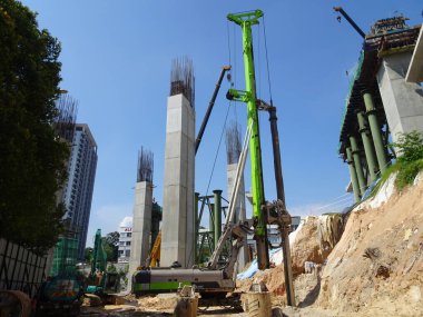 KUALA LUMPUR, MALAYSIA - 30 Mart 2020: İnşaat alanında yığın teçhizat makinesi. Bu makine vakıf inşaatı için hurda yığını sürüyordu. Yetenekli işçiler tarafından işletiliyor.. 