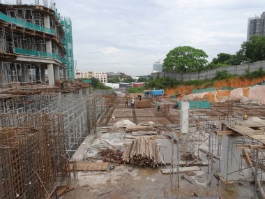 SEREMBAN, MALAYSIA - 30 Mart 2020: İnşaat işçileri inşaat alanında çelik takviye çubuğu üretiyorlar. Formatörleri kullanmadan önce küçük kabloları kullanarak birbirlerine bağladılar.. 
