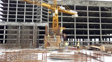 SEREMBAN, MALAYSIA - 30 Mart 2020: İnşaat işçileri inşaat alanında çelik takviye çubuğu üretiyorlar. Formatörleri kullanmadan önce küçük kabloları kullanarak birbirlerine bağladılar.. 
