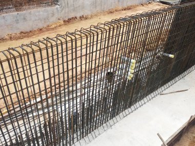 SEREMBAN, MALAYSIA - 30 Mart 2020: İnşaat işçileri inşaat alanında çelik takviye çubuğu üretiyorlar. Formatörleri kullanmadan önce küçük kabloları kullanarak birbirlerine bağladılar.. 