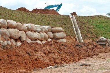 Taş kayalar yere yığılır ve istinat duvarı olarak kullanılır. Yağmurun yol açtığı toprak erozyonuna direniyor..