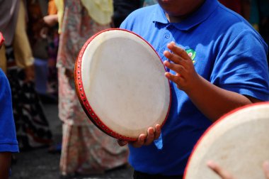 KUALA LUMPUR, MALAYSIA - 2 Mart 2019: Çocuk Malezya geleneksel düğün töreninde kompang oynuyor. Onlar kompang çalarken birlikte şarkılar söyleyecekler. Kompang geleneksel Malezya davuludur.. 