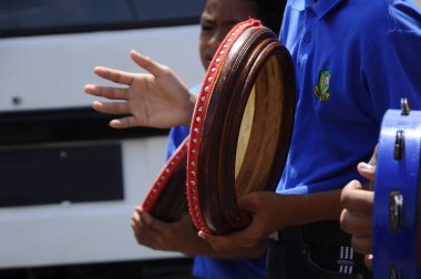 KUALA LUMPUR, MALAYSIA - 2 Mart 2019: Çocuk Malezya geleneksel düğün töreninde kompang oynuyor. Onlar kompang çalarken birlikte şarkılar söyleyecekler. Kompang geleneksel Malezya davuludur.. 