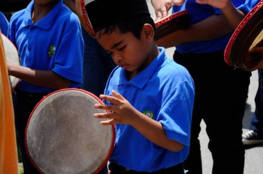 KUALA LUMPUR, MALAYSIA - 2 Mart 2019: Çocuk Malezya geleneksel düğün töreninde kompang oynuyor. Onlar kompang çalarken birlikte şarkılar söyleyecekler. Kompang geleneksel Malezya davuludur.. 