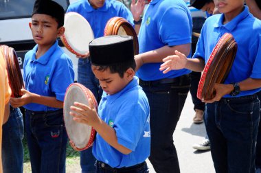 KUALA LUMPUR, MALAYSIA - 2 Mart 2019: Çocuk Malezya geleneksel düğün töreninde kompang oynuyor. Onlar kompang çalarken birlikte şarkılar söyleyecekler. Kompang geleneksel Malezya davuludur.. 