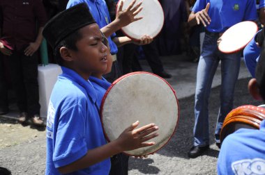 KUALA LUMPUR, MALAYSIA - 2 Mart 2019: Çocuk Malezya geleneksel düğün töreninde kompang oynuyor. Onlar kompang çalarken birlikte şarkılar söyleyecekler. Kompang geleneksel Malezya davuludur.. 
